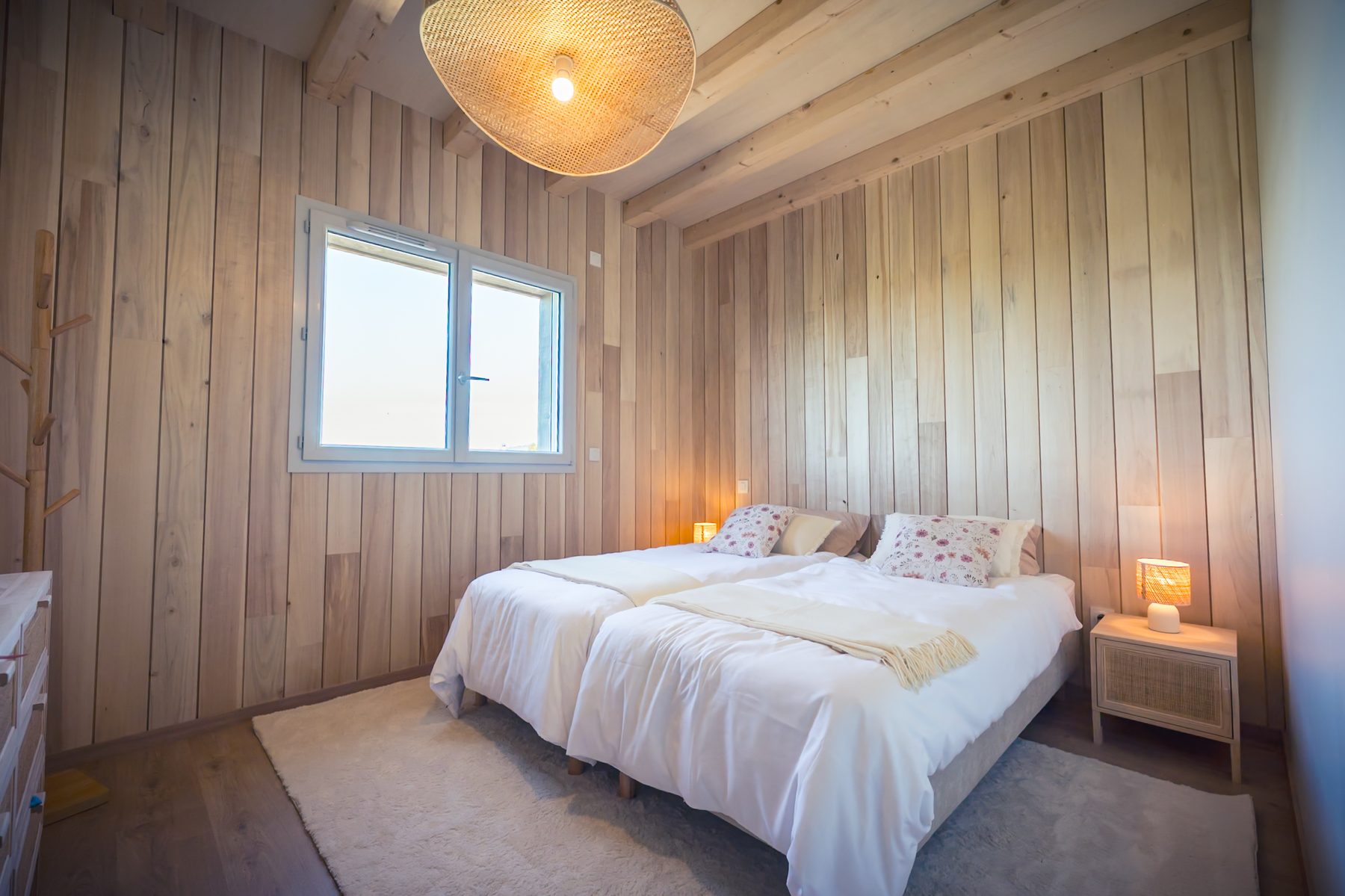Chambre avec deux lits et luminaires naturels