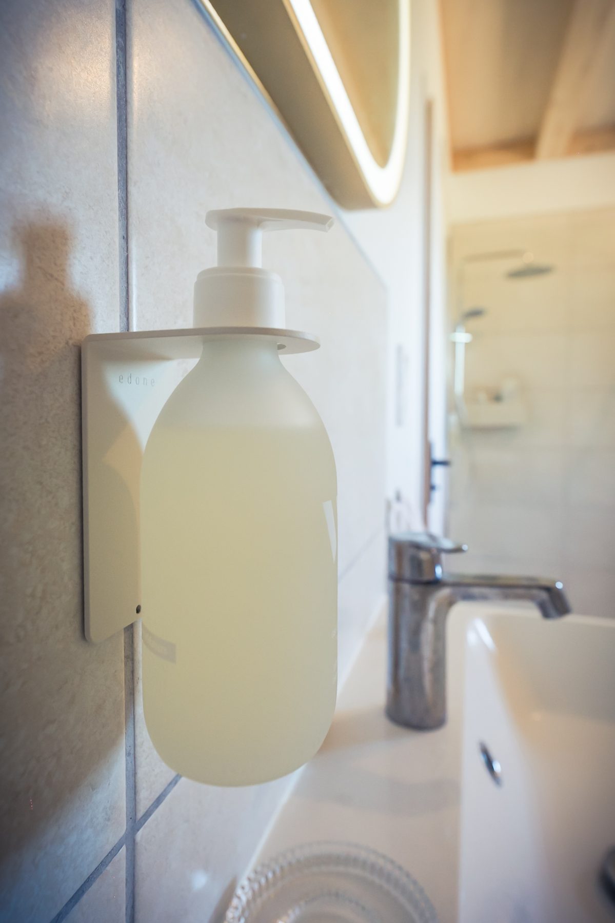Détail de salle de bain avec distributeur et vasque