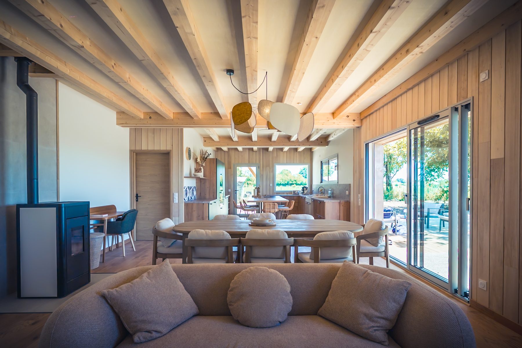 Pièce de vie en bois avec salon, table et cuisine