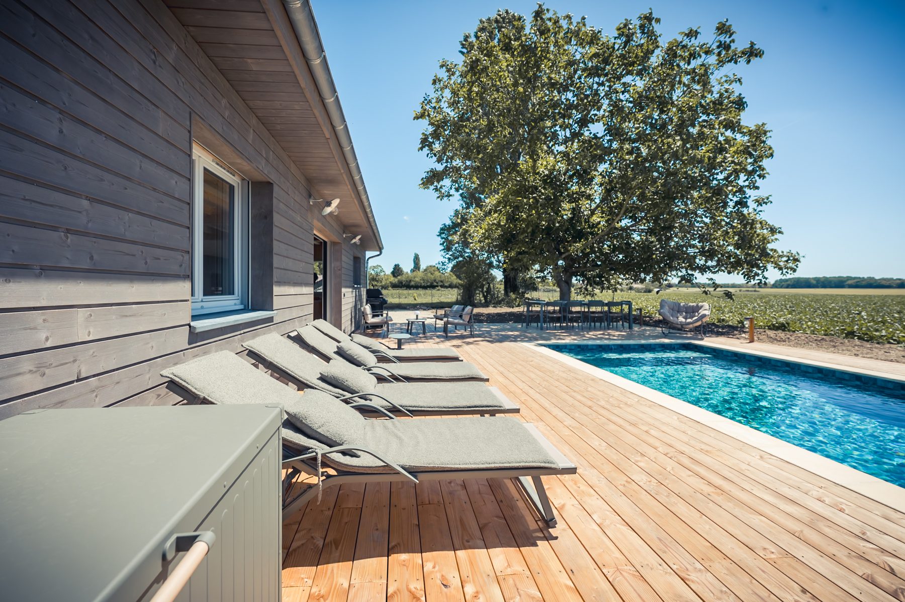 Transats au bord du bassin et terrasse bois